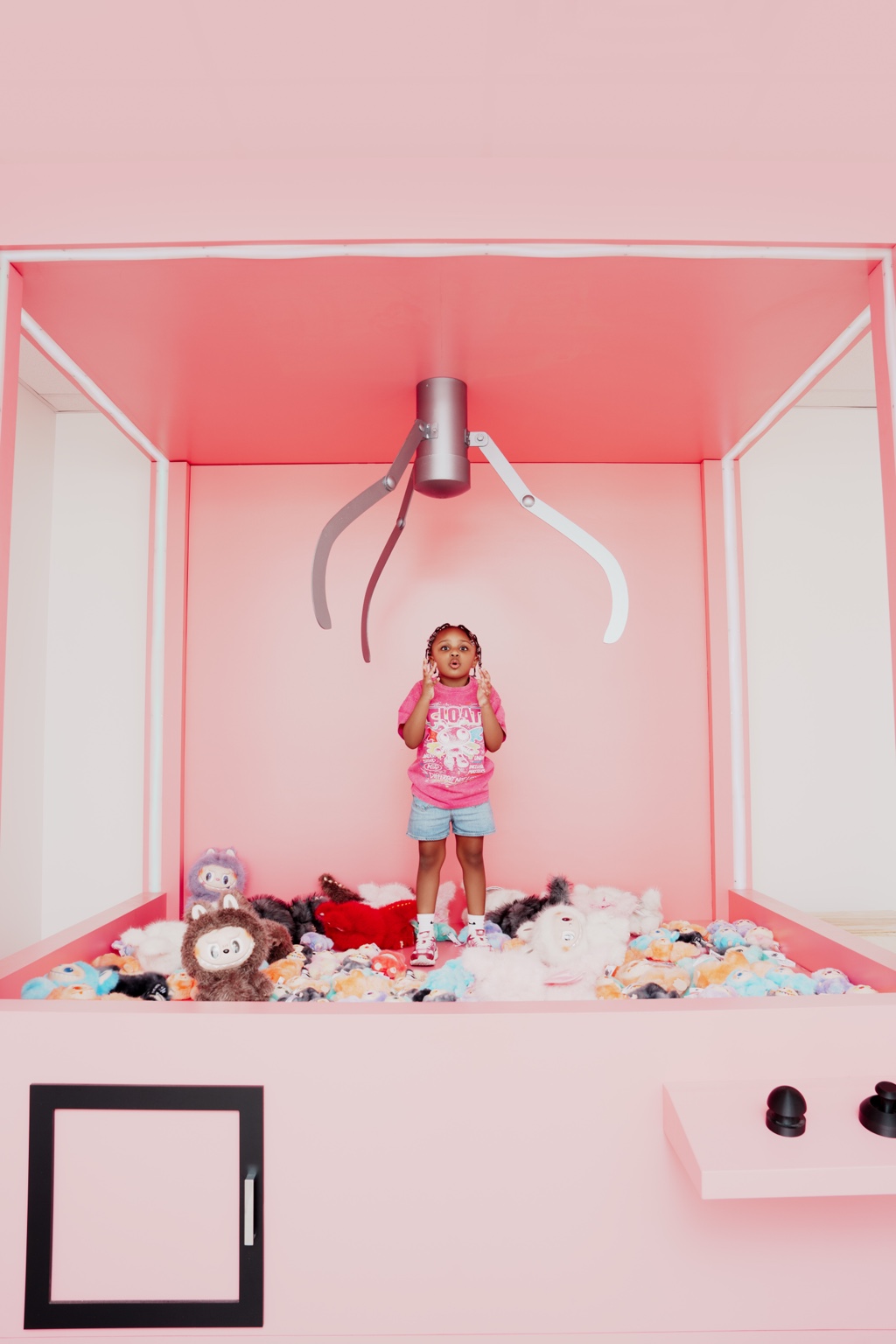 River standing in a life sized claw machine during an autism acceptance themed photo shoot